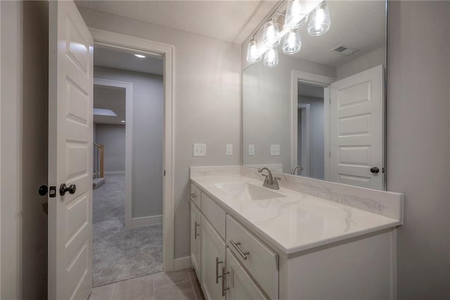 bathroom featuring vanity, tile patterned flooring, and a textured ceiling