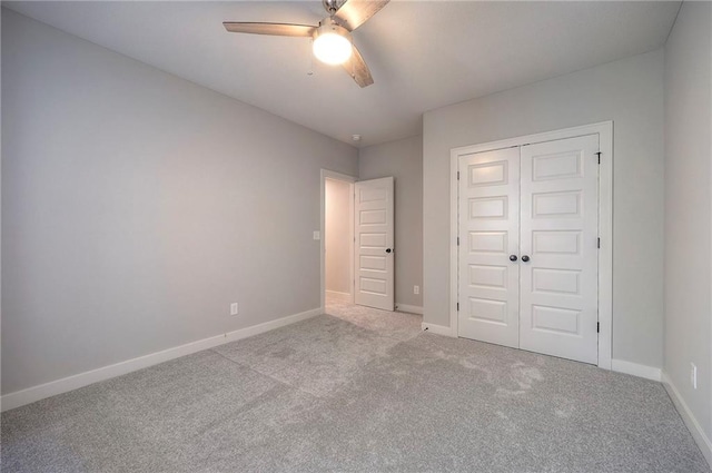 unfurnished bedroom with ceiling fan, light colored carpet, and a closet