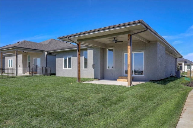 rear view of house featuring ceiling fan, a yard, and a patio