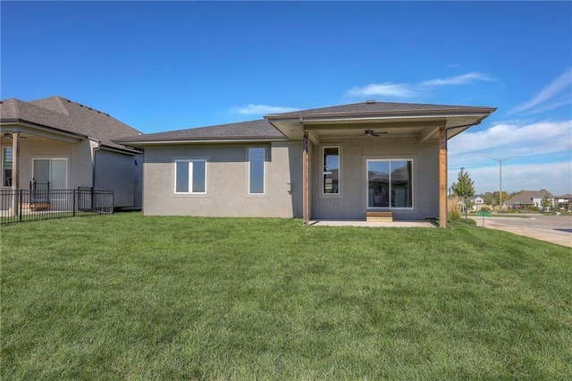 rear view of property with a patio area, ceiling fan, and a lawn