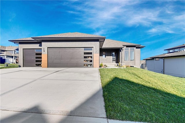 prairie-style home with a front yard and a garage