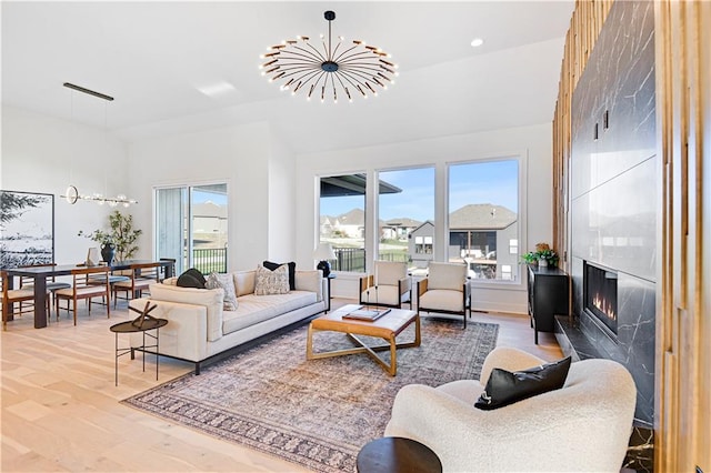 living room featuring a fireplace, a chandelier, and hardwood / wood-style flooring