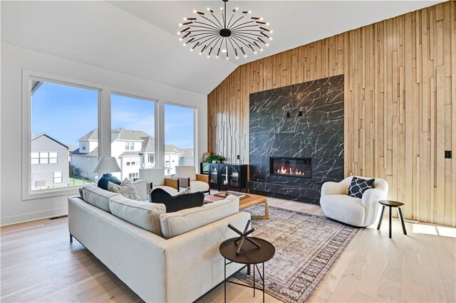 living room featuring lofted ceiling, a healthy amount of sunlight, wood-type flooring, and a fireplace