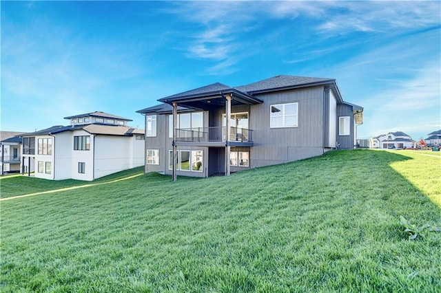 back of house with a lawn and a balcony