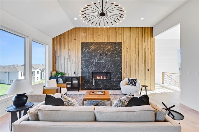 17321 Gillette St, Overland Park, KS 66221 - living room with wood walls, wood finished floors, vaulted ceiling, a high end fireplace, and recessed lighting