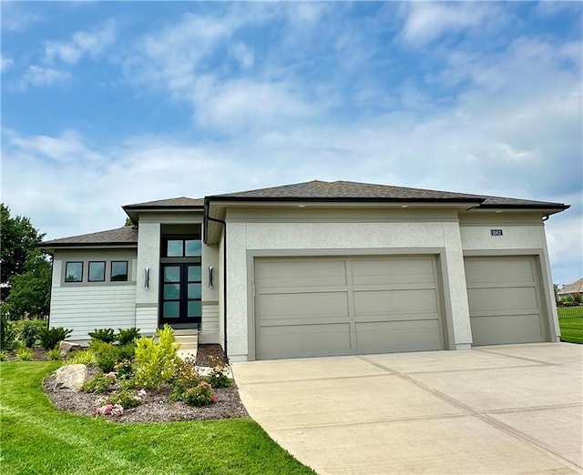 prairie-style home with a garage and a front lawn