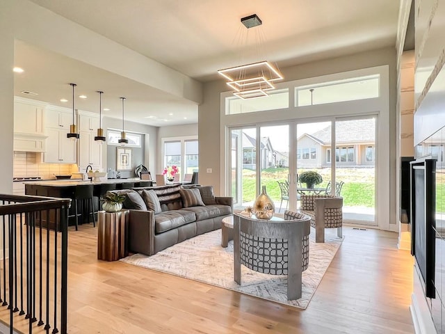 living room featuring sink and light hardwood / wood-style flooring