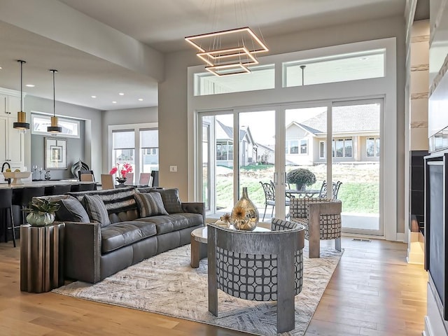 living room with an inviting chandelier and light hardwood / wood-style flooring