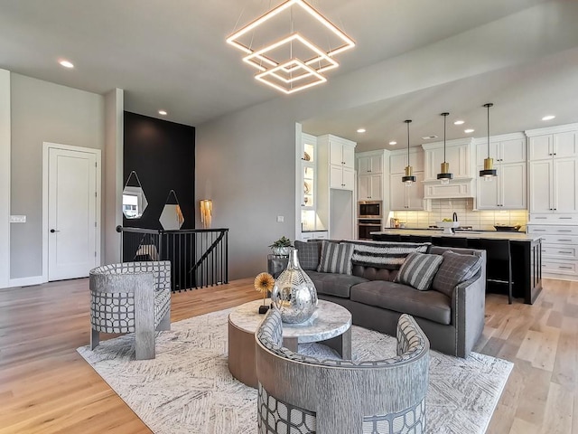 living room featuring sink, a notable chandelier, and light hardwood / wood-style floors