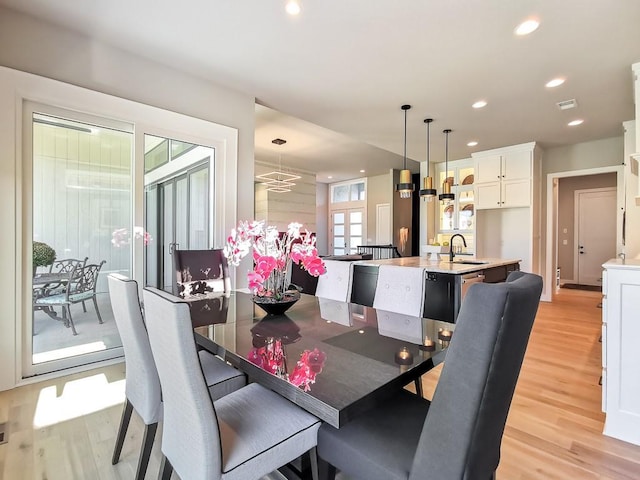 dining room with sink and light hardwood / wood-style flooring