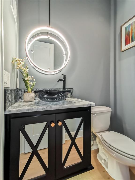 bathroom with hardwood / wood-style flooring, vanity, and toilet