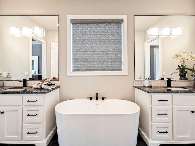 bathroom with vanity and a tub