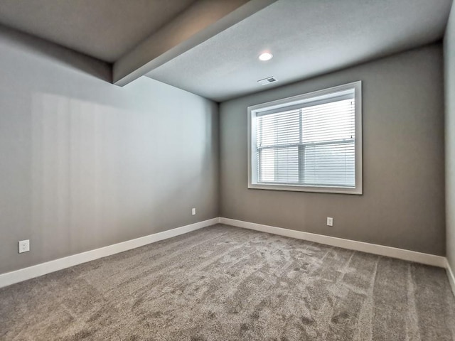 unfurnished room featuring beam ceiling and carpet flooring