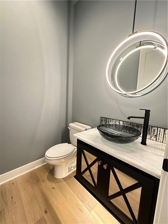 bathroom featuring vanity, hardwood / wood-style floors, and toilet