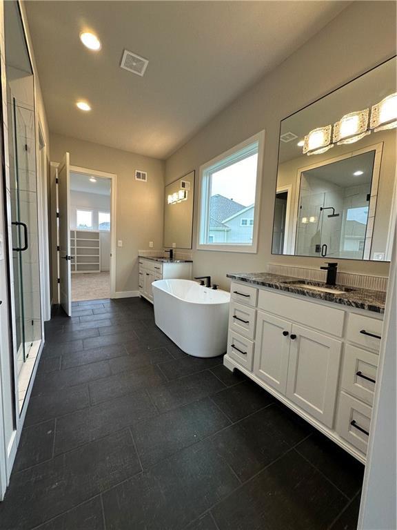 bathroom featuring plus walk in shower and vanity