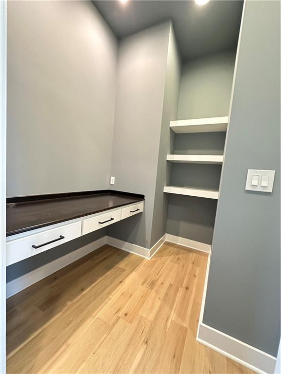 spacious closet with light hardwood / wood-style flooring