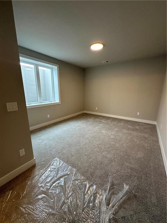 spare room with dark colored carpet