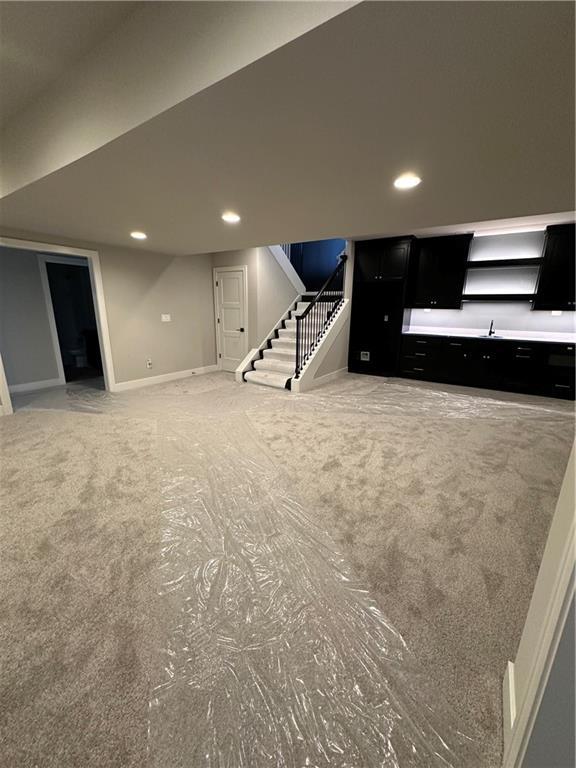 basement featuring carpet floors and sink