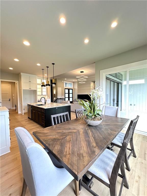 dining space with sink and light wood-type flooring