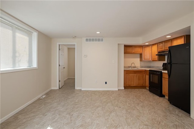 kitchen featuring sink, black appliances, and light tile floors