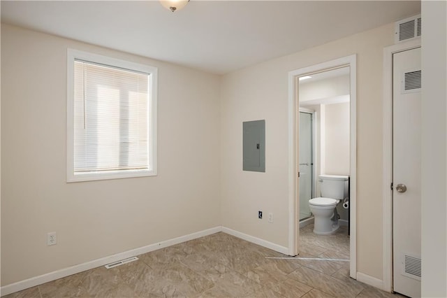 unfurnished bedroom with ensuite bathroom and light tile floors