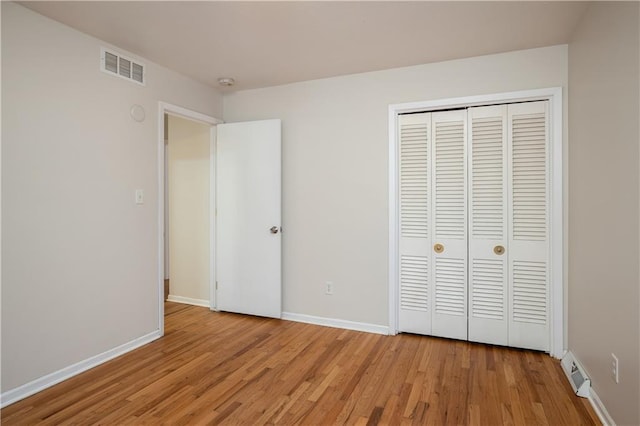 unfurnished bedroom with a closet and light hardwood / wood-style flooring