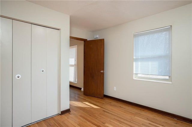 unfurnished bedroom featuring light hardwood / wood-style flooring and a closet