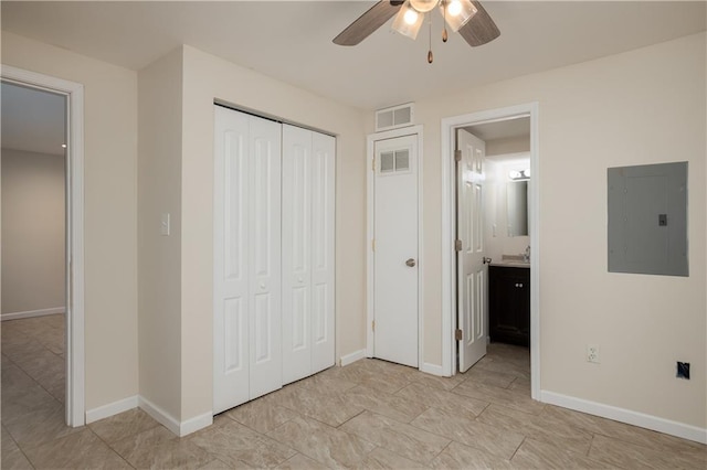 unfurnished bedroom featuring ceiling fan, connected bathroom, light tile flooring, and a closet