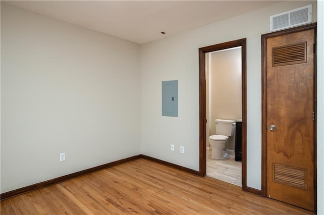 unfurnished bedroom featuring ensuite bath and light wood-type flooring