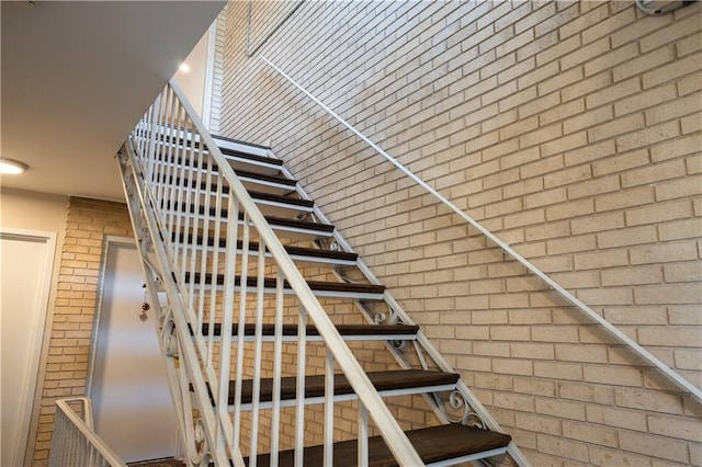 stairs featuring brick wall