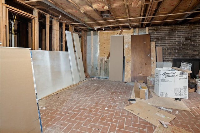 basement with a fireplace and brick wall