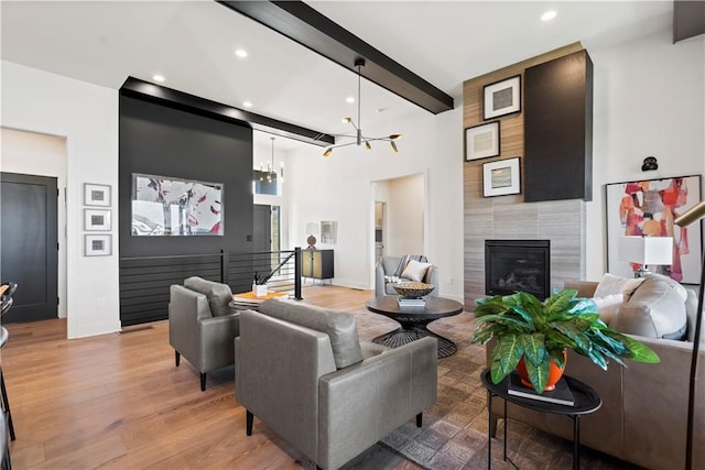 11522 S Zarda Dr, Olathe, KS 66061 - living room featuring beamed ceiling, recessed lighting, a tile fireplace, a chandelier, and light wood-type flooring