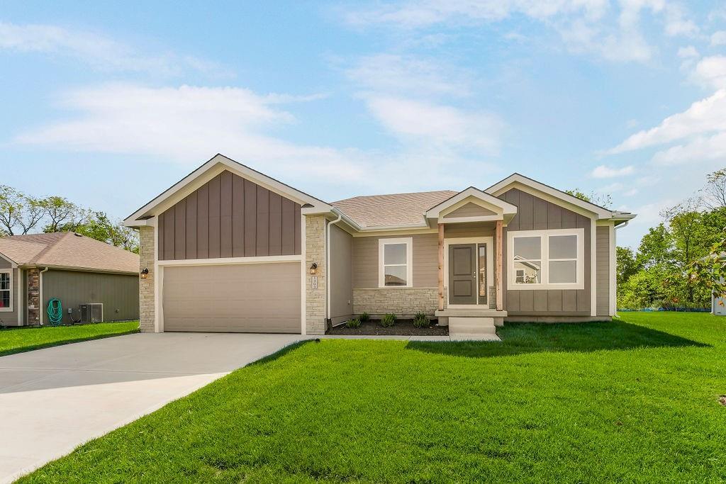 ranch-style house featuring driveway, a front lawn, board and batten siding, and cooling unit