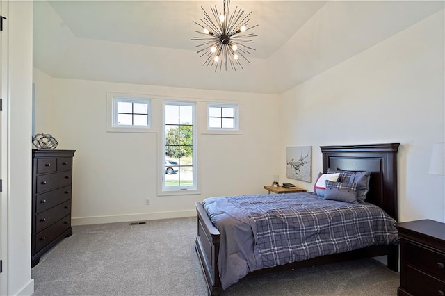 carpeted bedroom with a notable chandelier and a raised ceiling