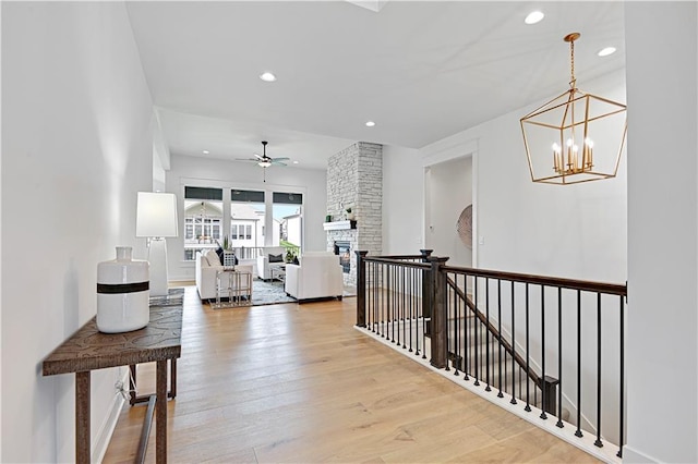 hallway with light hardwood / wood-style floors and an inviting chandelier