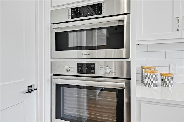 kitchen with white cabinetry, a mail area, and double oven