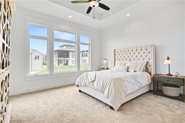 bedroom with carpet, ceiling fan, and a raised ceiling