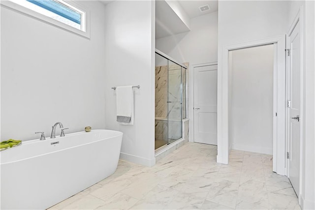 bathroom featuring shower with separate bathtub