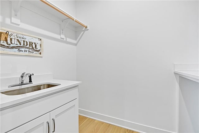 laundry room with light hardwood / wood-style flooring and sink