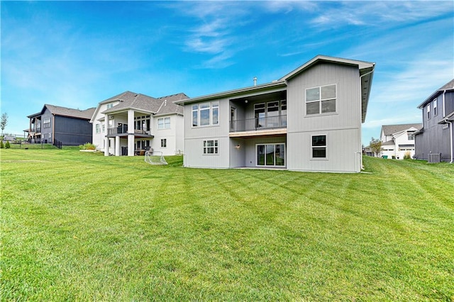 rear view of property featuring a yard and central air condition unit