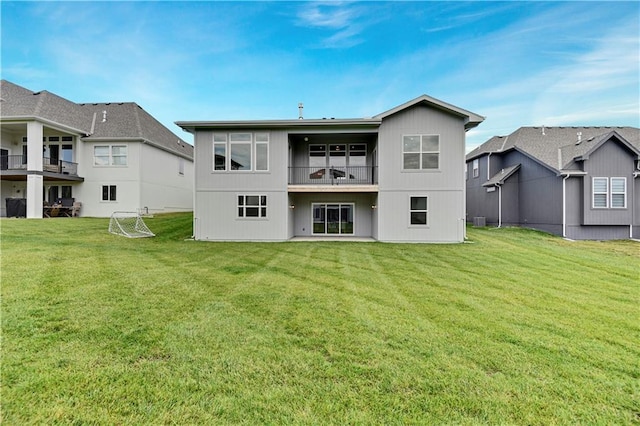 rear view of house featuring a yard and a balcony