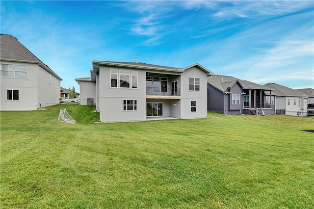 rear view of property featuring a lawn