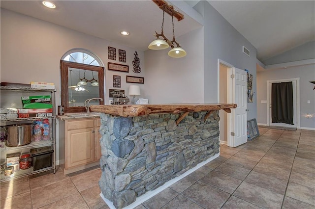 bar featuring sink, light tile patterned floors, pendant lighting, and vaulted ceiling