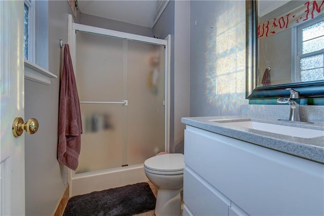 bathroom featuring vanity, an enclosed shower, and toilet