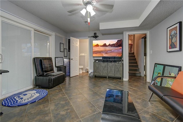 tiled living room with a textured ceiling and ceiling fan