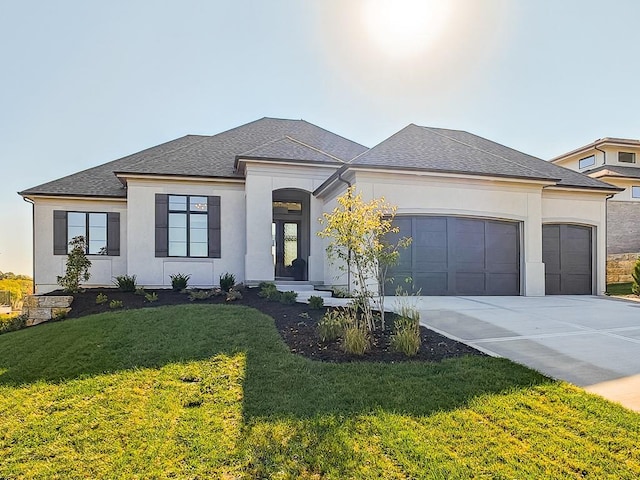 prairie-style home featuring a garage and a front lawn