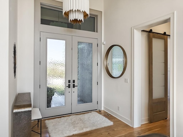 entryway featuring french doors, a barn door, and hardwood / wood-style flooring