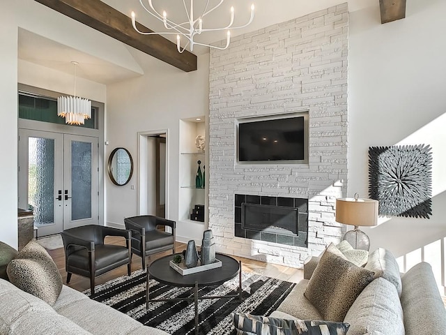 living room featuring hardwood / wood-style floors, french doors, a stone fireplace, beamed ceiling, and a notable chandelier