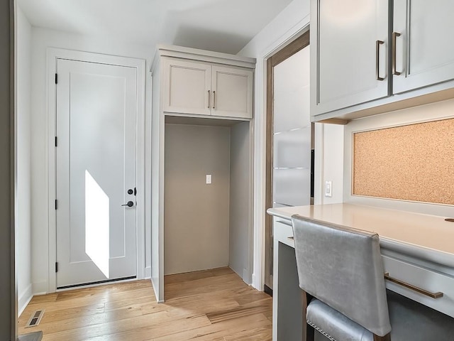 office with built in desk and light wood-type flooring