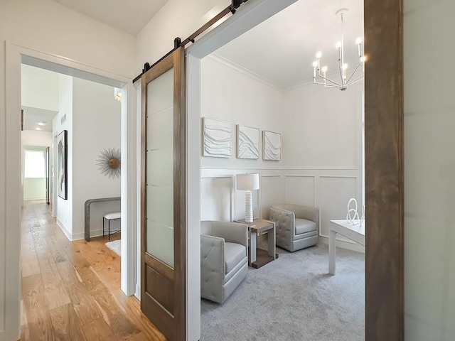 living area featuring a barn door, light colored carpet, and a notable chandelier